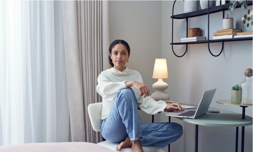Related Woman sitting by lap top in bedroom
